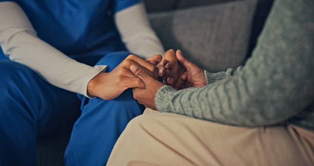 Caregiver gently holding a client's hands in support